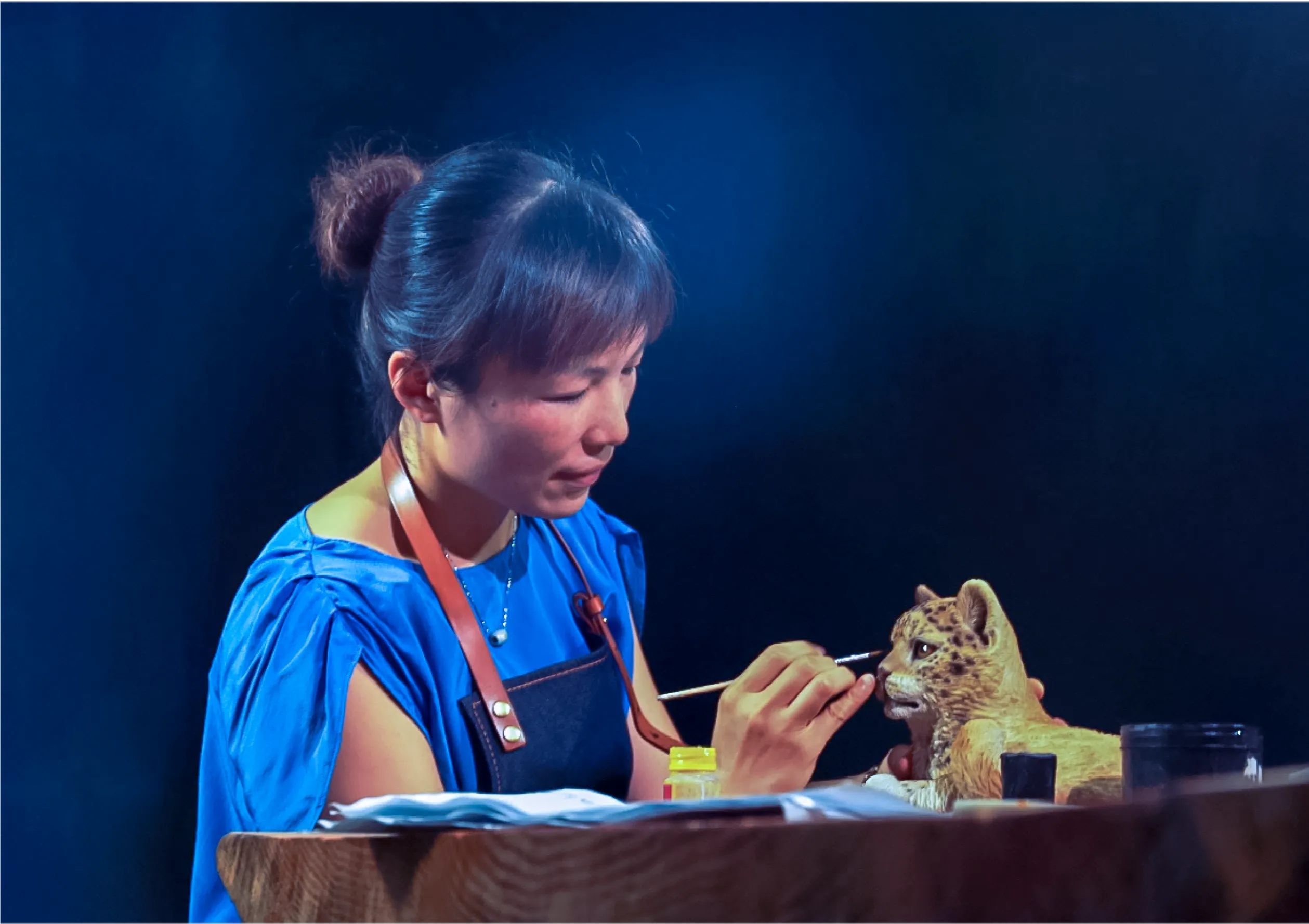 Female artist paints the face of cat
